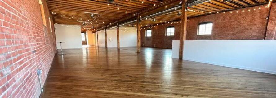 Hardwood floor refinishing in progress inside Leawood, KS industrial loft with brick walls and exposed beams