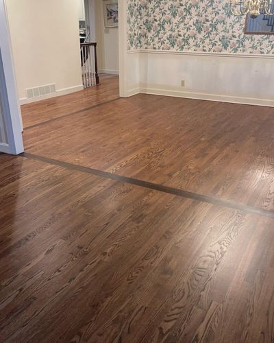 Hardwood floor refinishing in Lenexa, KS, showcasing a rich, even-toned hardwood dining room with ample space