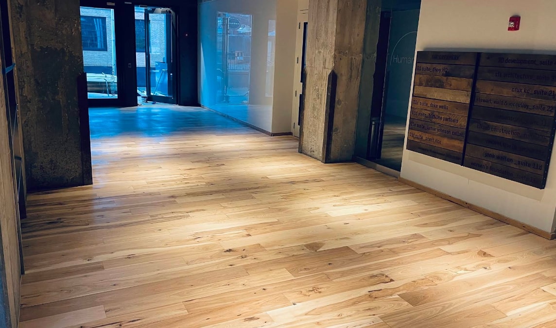 Wood floor repair scene in progress hallway, Kansas City KS office with fresh wood planks and modern decor